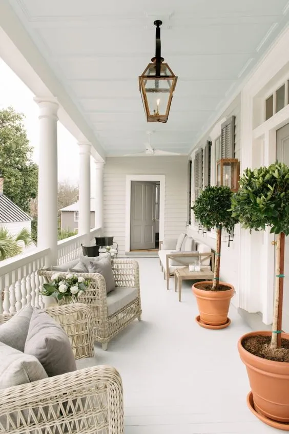 Channel a coastal aesthetic with white wicker furniture and terracotta planters. Topiary trees add height and structure, while soft grey cushions keep the look airy and sophisticated. This design pairs perfectly with the clean lines of a white-washed porch, making it ideal for springtime lounging.